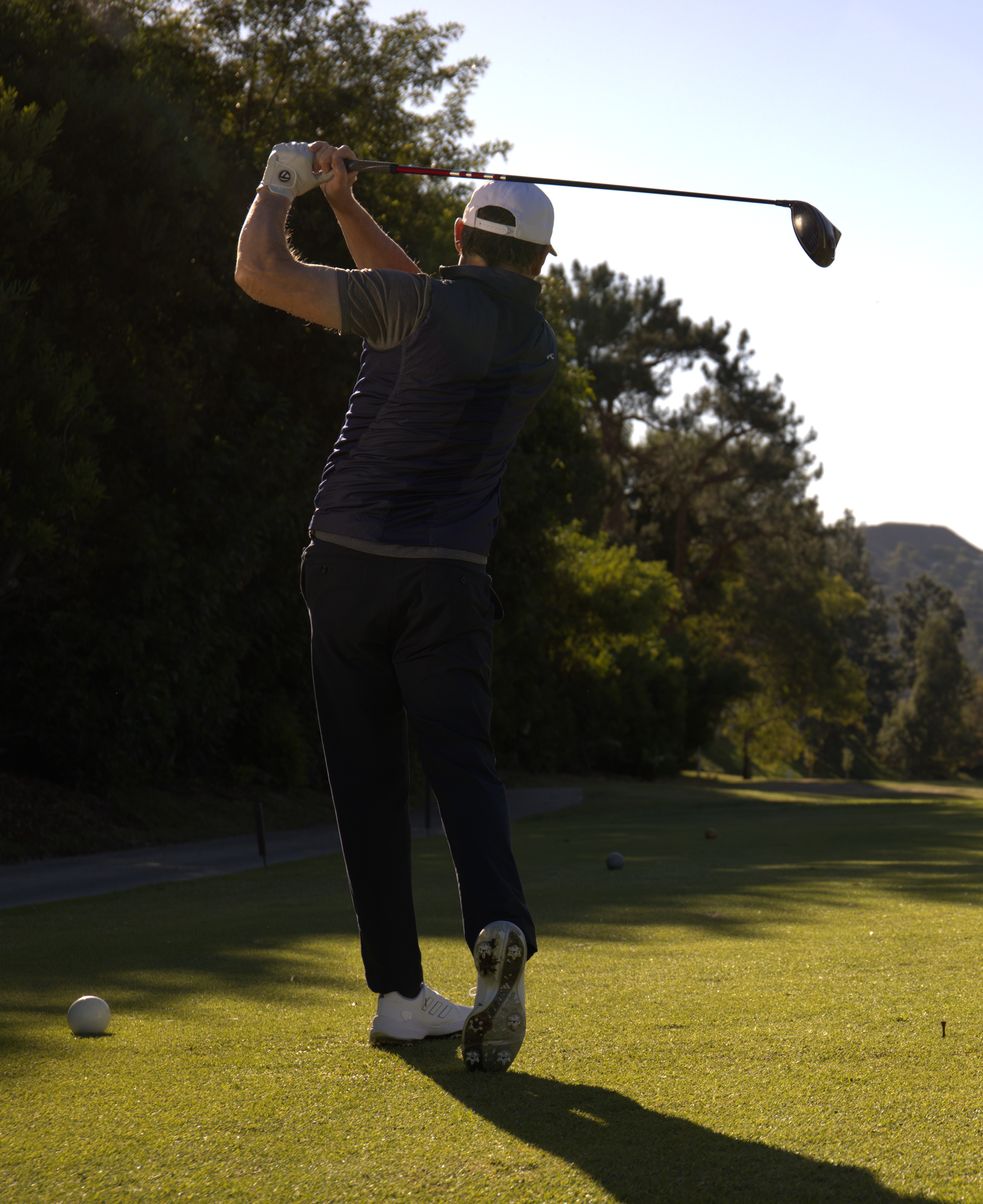 Golfer moving freely through a full, unrestricted follow-through with a driver