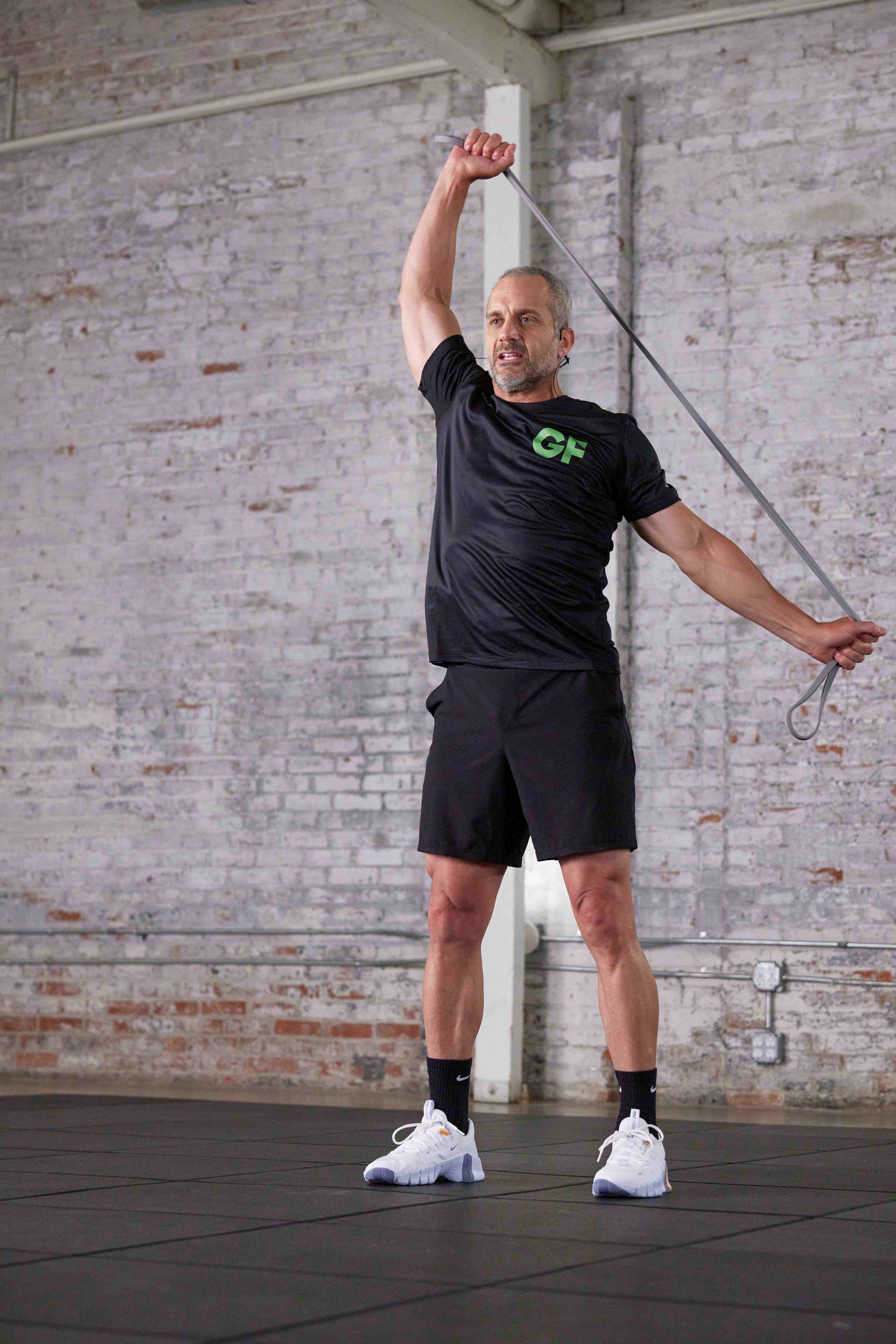 Golf Fit trainer performing an overhead diagonal band stretch