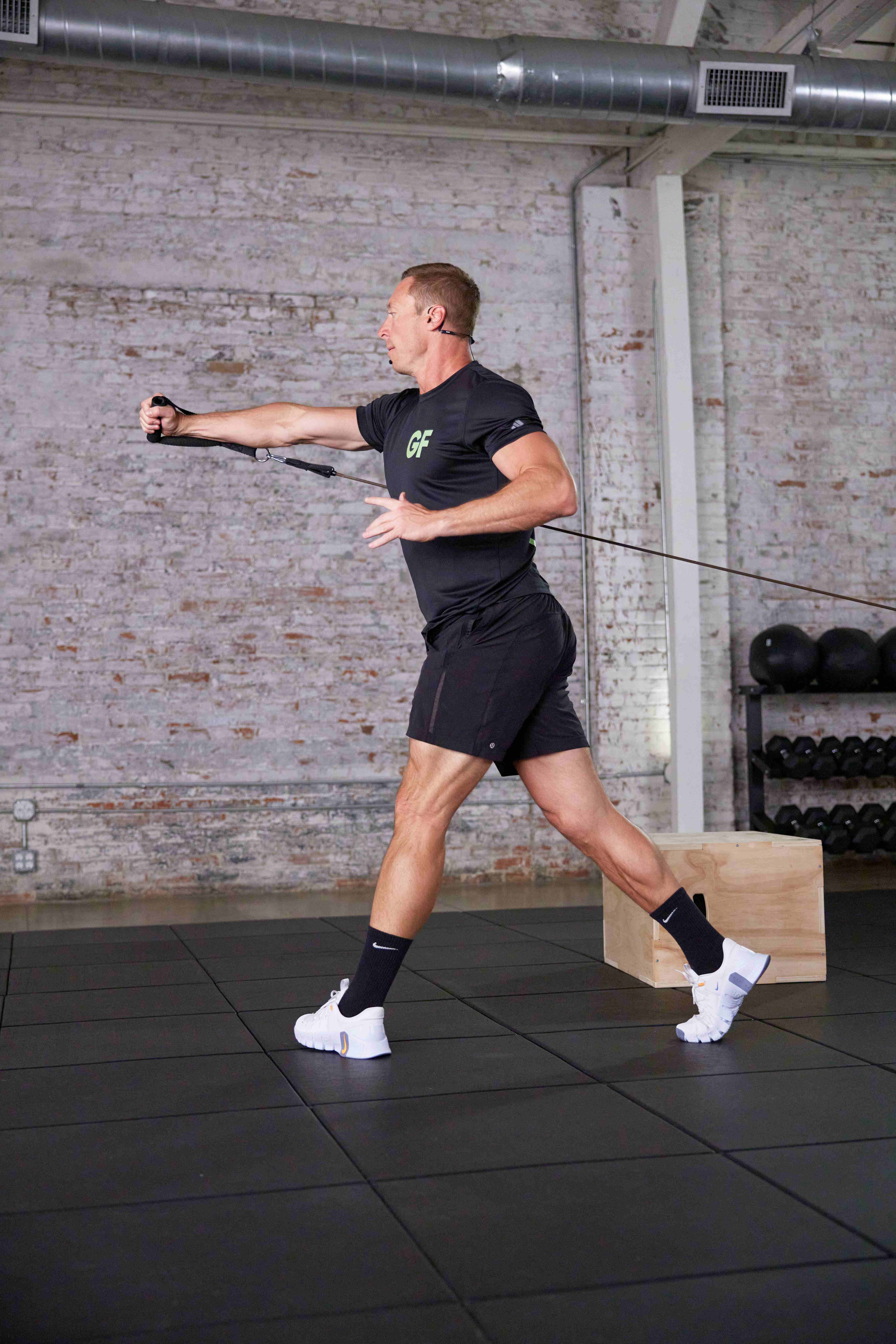 Golf Fit trainer driving a resistance band through a rotational lunge