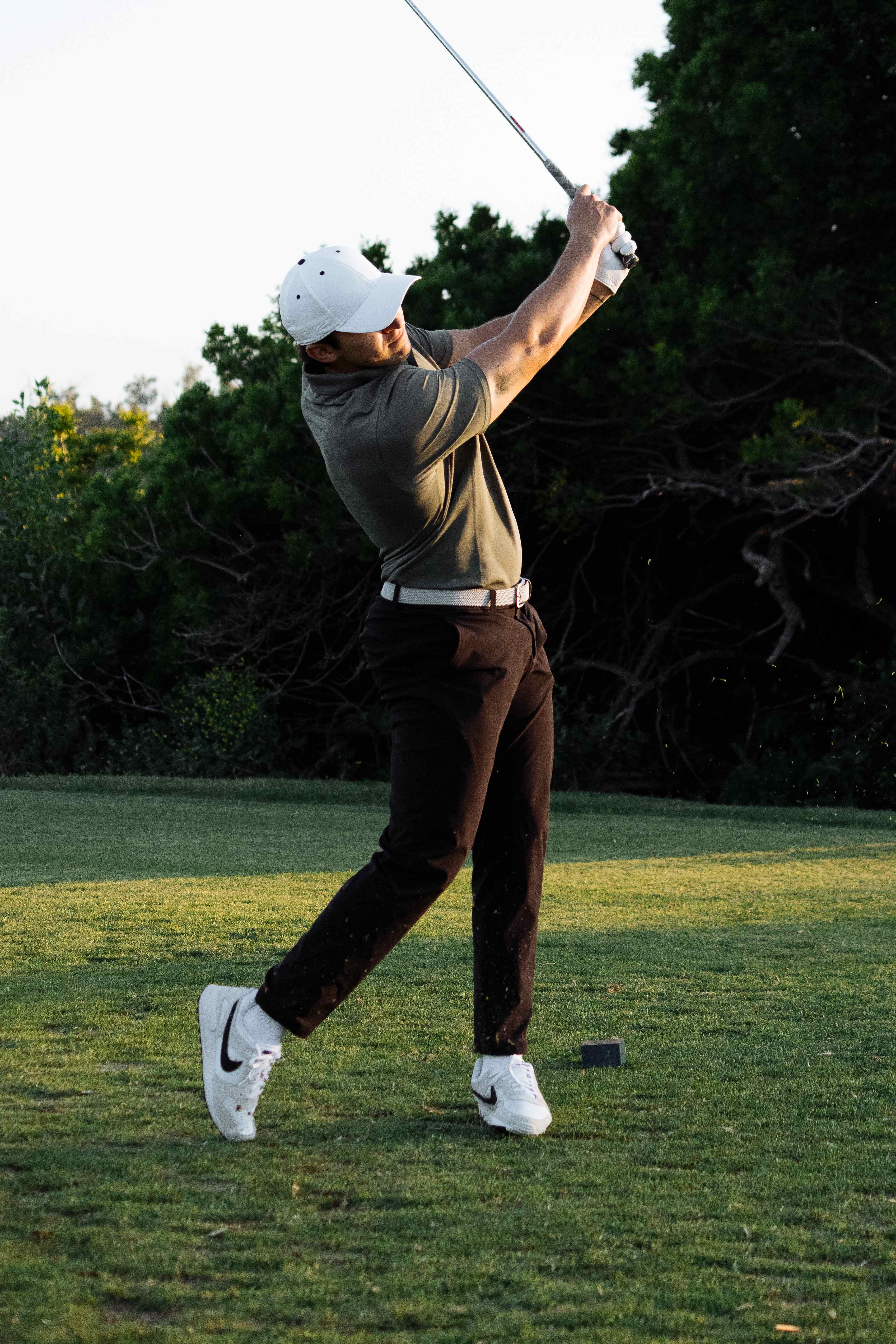 Golfer holding his follow-through after a swing on the course